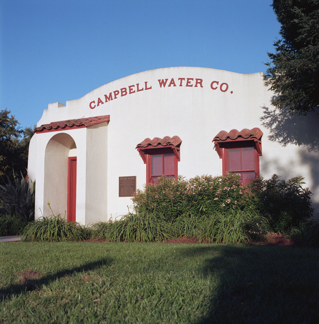 Nice old water_company building on a corner of Campbell Avenue, standing below  the water tower